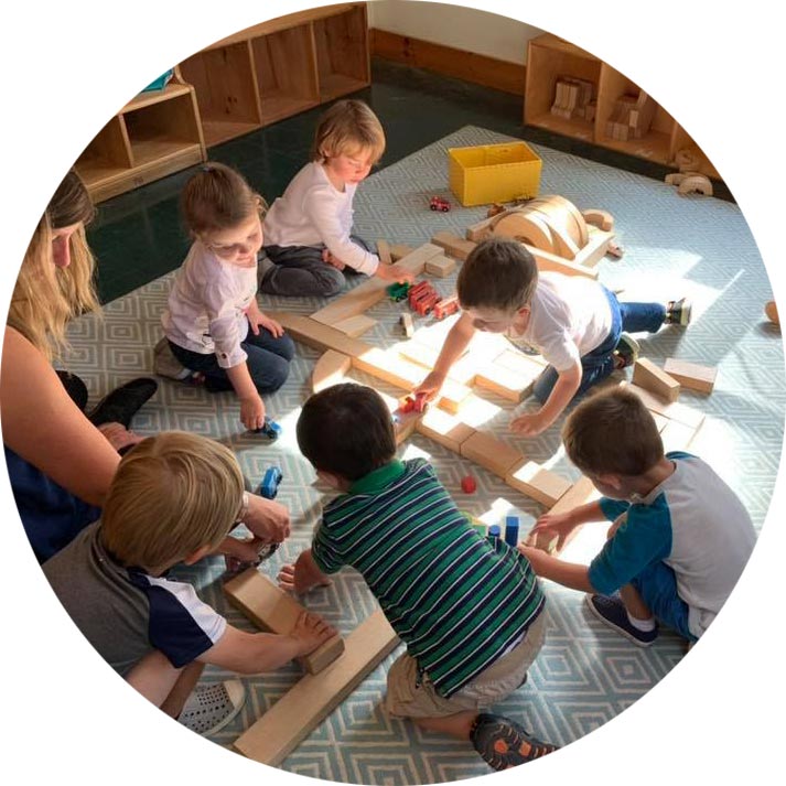 Preschool students collaborating on a toy railway system